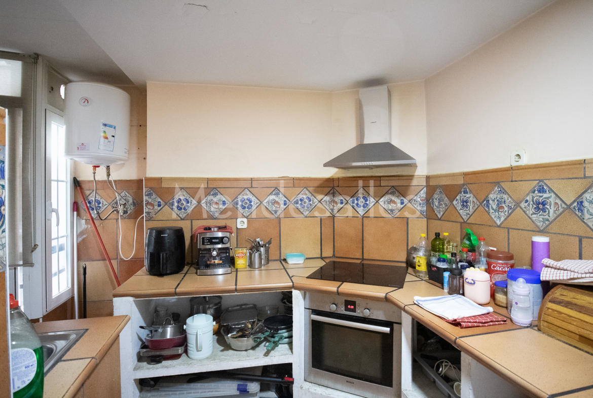 Cocina con fregadero, horno y campana extractora