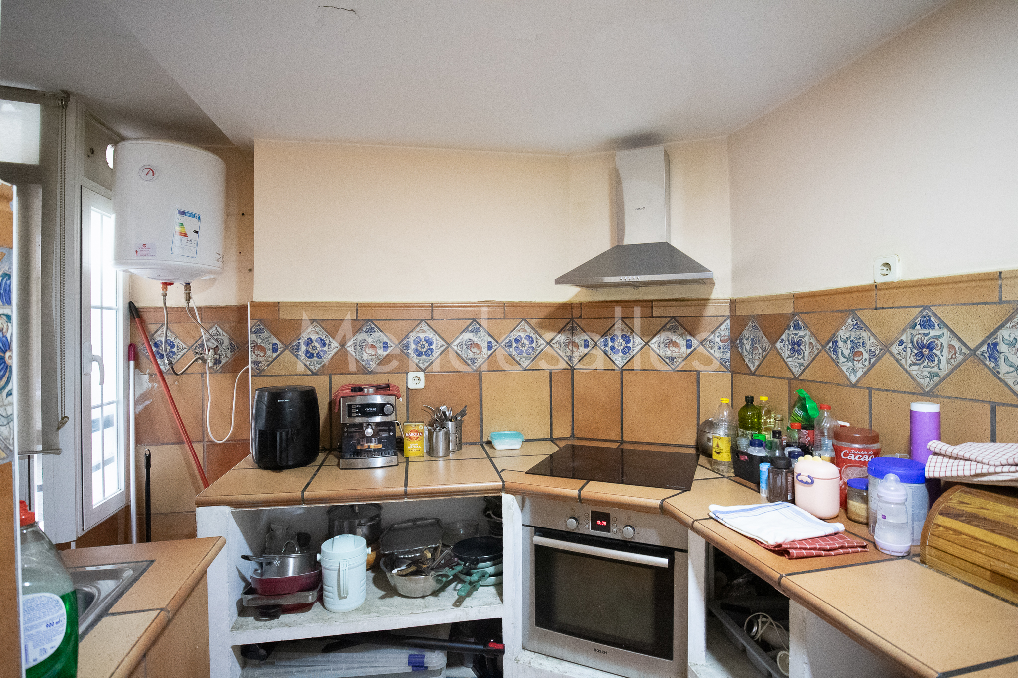 Cocina con fregadero, horno y campana extractora